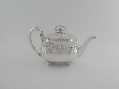 Appraisal: A George III barge-shaped teapot on ball feet with reeded