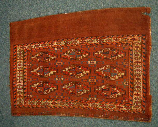 Appraisal: Rectangular brown ground mat decorated with a geometric red and