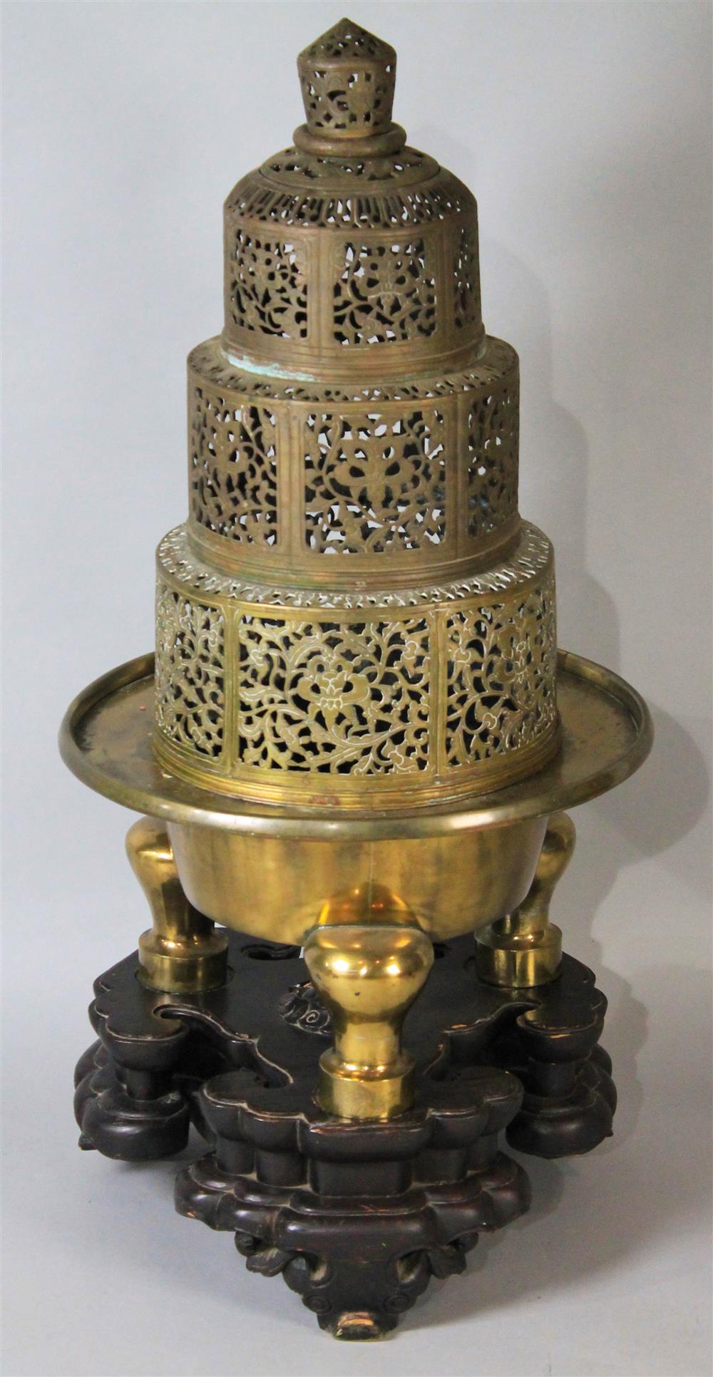 Appraisal: CHINESE GILT-METAL LARGE TRIPOD CENSER the tall three-tiered pierced cover