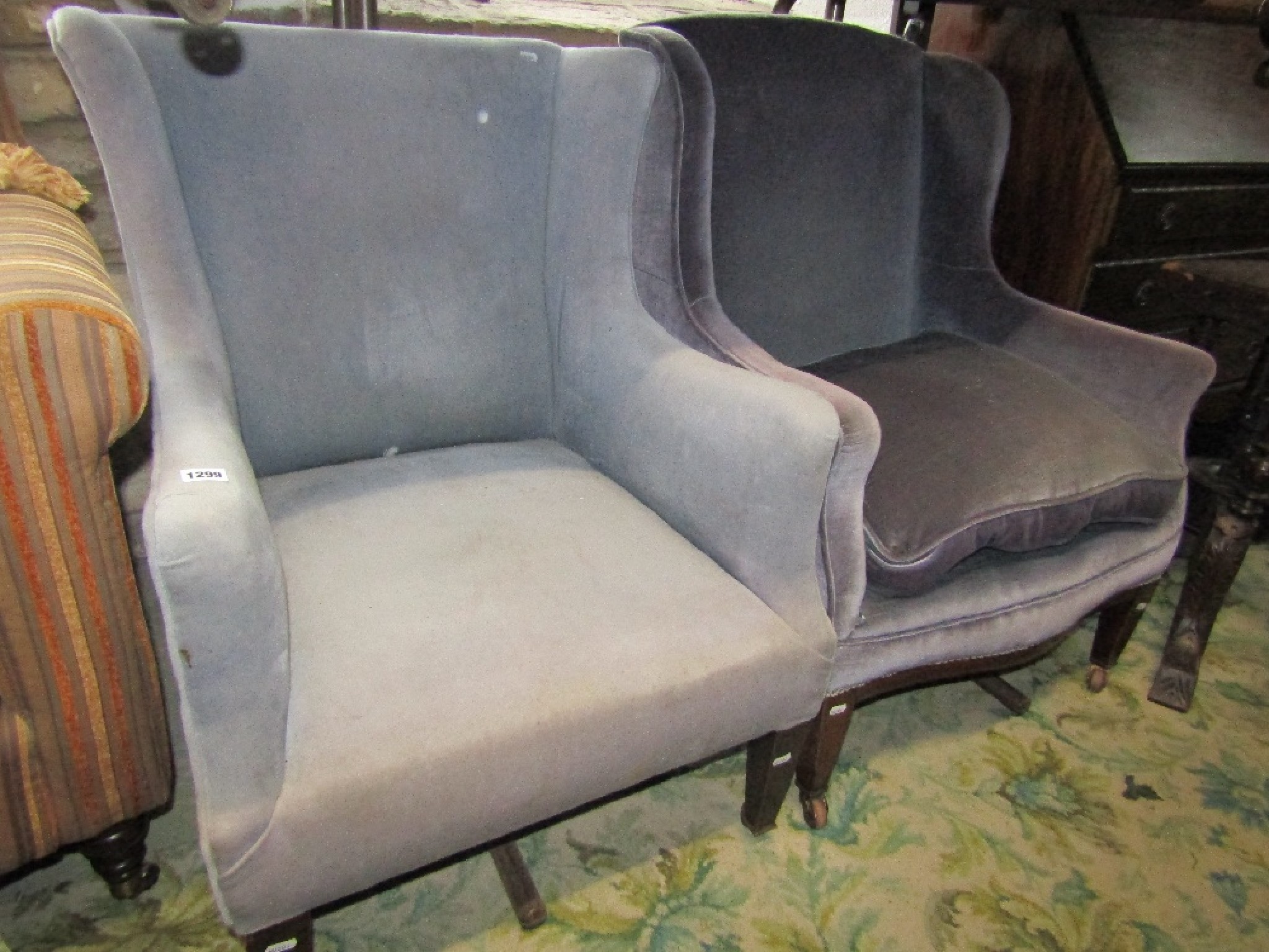 Appraisal: An Edwardian low wing back armchair with shaped outline and