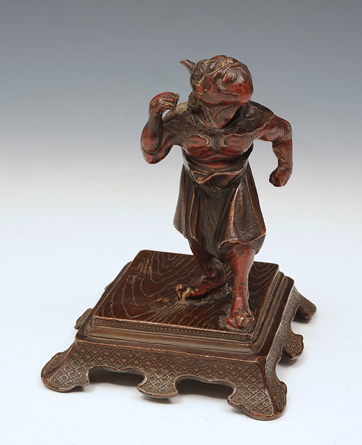 Appraisal: A JAPANESE PAINTED BRONZE MODEL of a standing Oni on