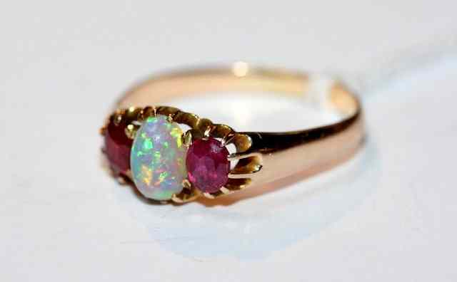 Appraisal: A THREE STONE RUBY AND OPAL DRESS RING claw set