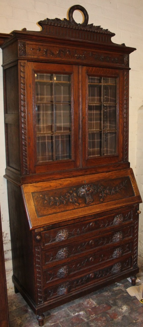 Appraisal: A thC oak bureau bookcase heavily carved with a classical