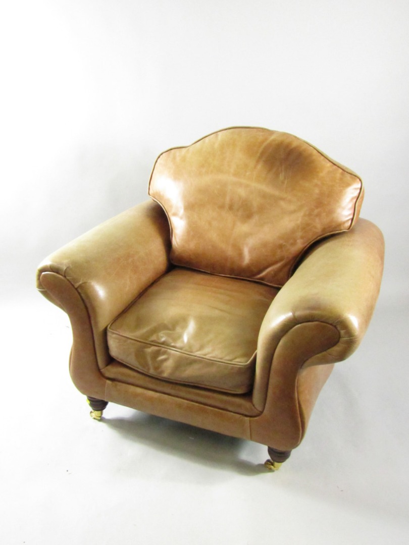 Appraisal: A mahogany and tan leather armchair raised on turned legs