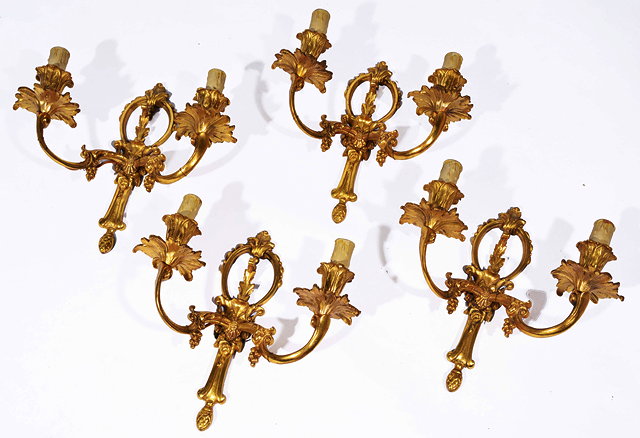 Appraisal: A SET OF FOUR GILT METAL TWO BRANCH WALL LIGHTS