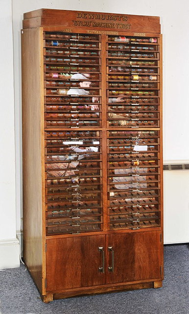 Appraisal: A DEWHURST'S 'SYLKO' OAK HABERDASHERY CABINET with fifty glass fronted