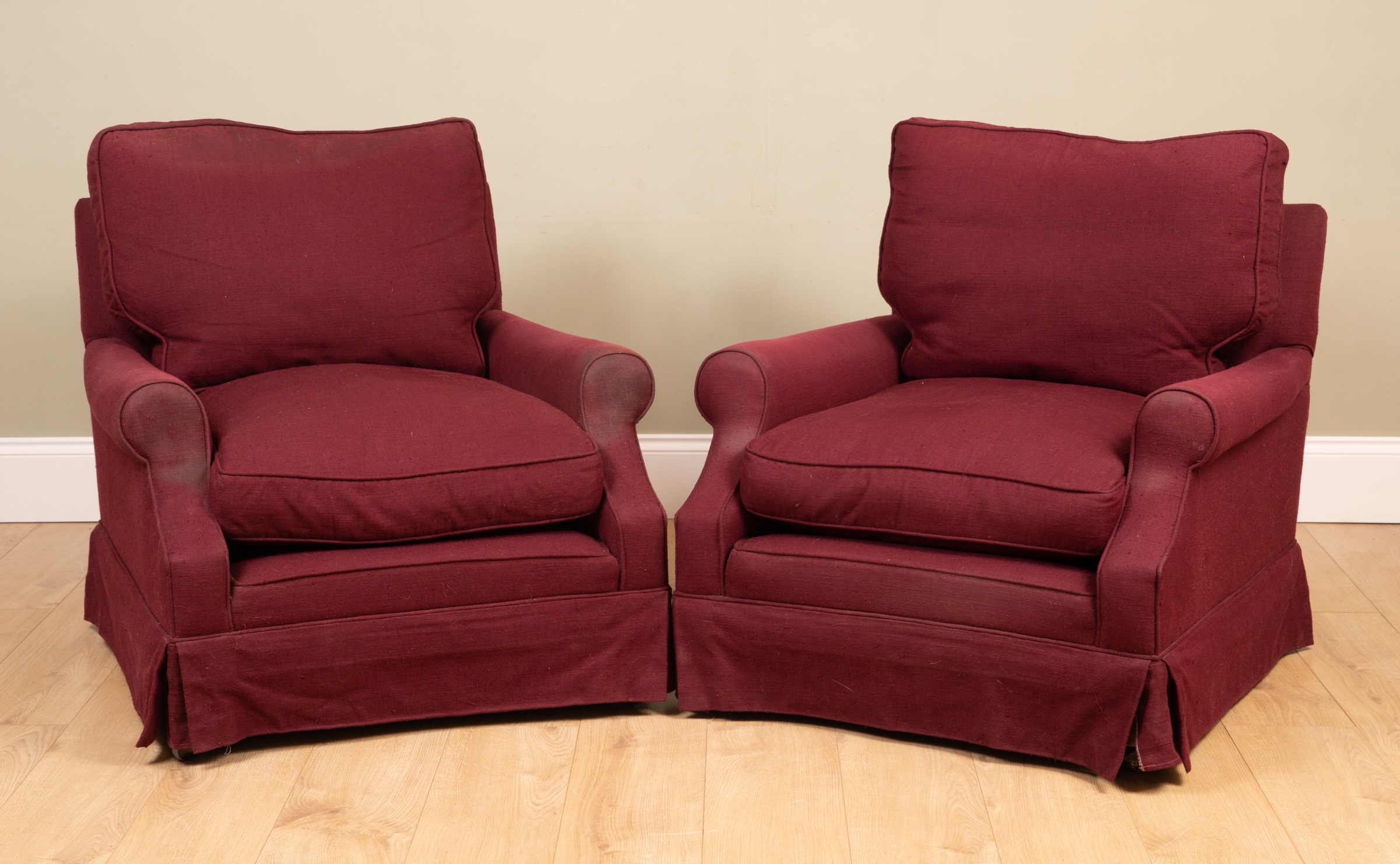 Appraisal: A pair of maroon upholstered armchairs on square supports and