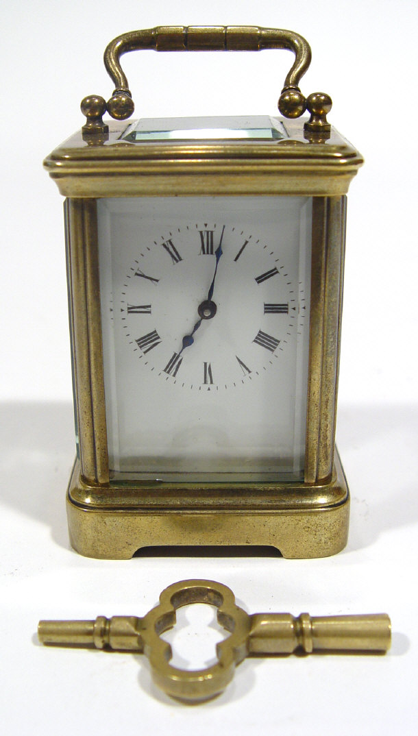 Appraisal: Miniature brass carriage clock with swing handle bevelled glass panels