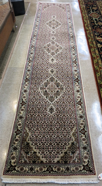 Appraisal: HAND KNOTTED ORIENTAL HALL RUG Persian Bidjar design having a