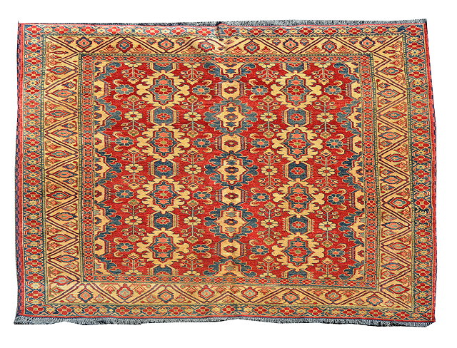 Appraisal: A PAKISTAN RUST GROUND RUG with geometric and flower designs