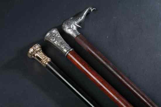 Appraisal: THREE WALKING STICKS Including one with sterling handle modelled as