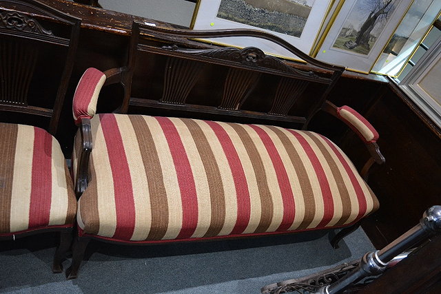 Appraisal: An Edwardian mahogany sofawith striped upholstery and carved back and