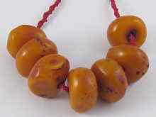 Appraisal: A naturalistic amber necklace comprising seven large beads each measuring