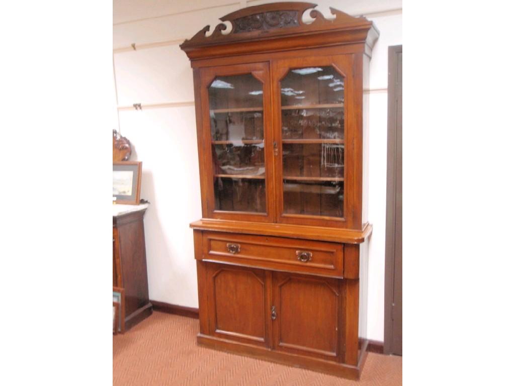 Appraisal: A late Victorian walnut cabinet bookcase with two glazed doors