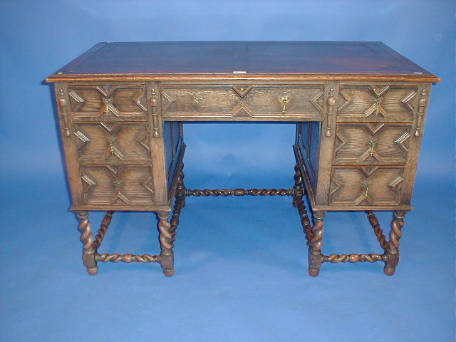 Appraisal: A Jacobean style oak kneehole desk with barley twist framing