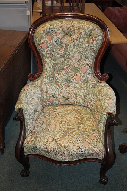 Appraisal: A VICTORIAN MAHOGANY FRAMED BUTTON BACK ARMCHAIR with scroll arms