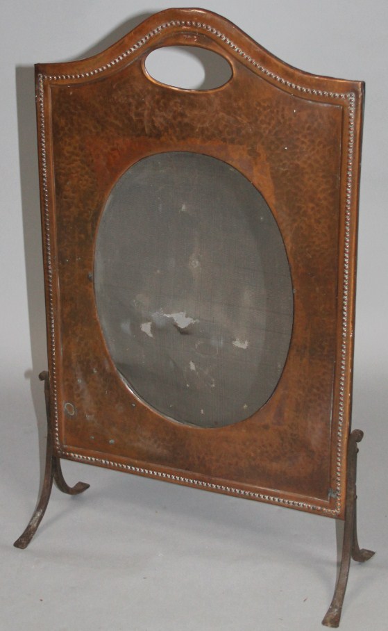 Appraisal: An Edwardian hammered copper fire screen with shaped outline and