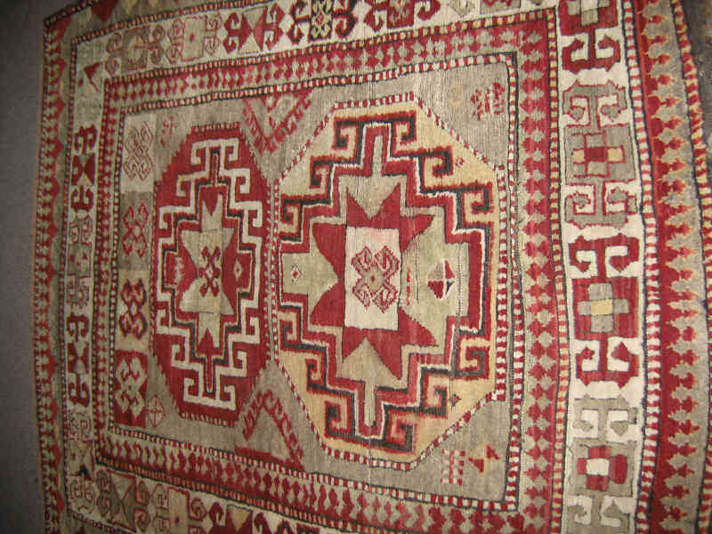 Appraisal: KAZAK THROW RUG The tan field of rams horn and