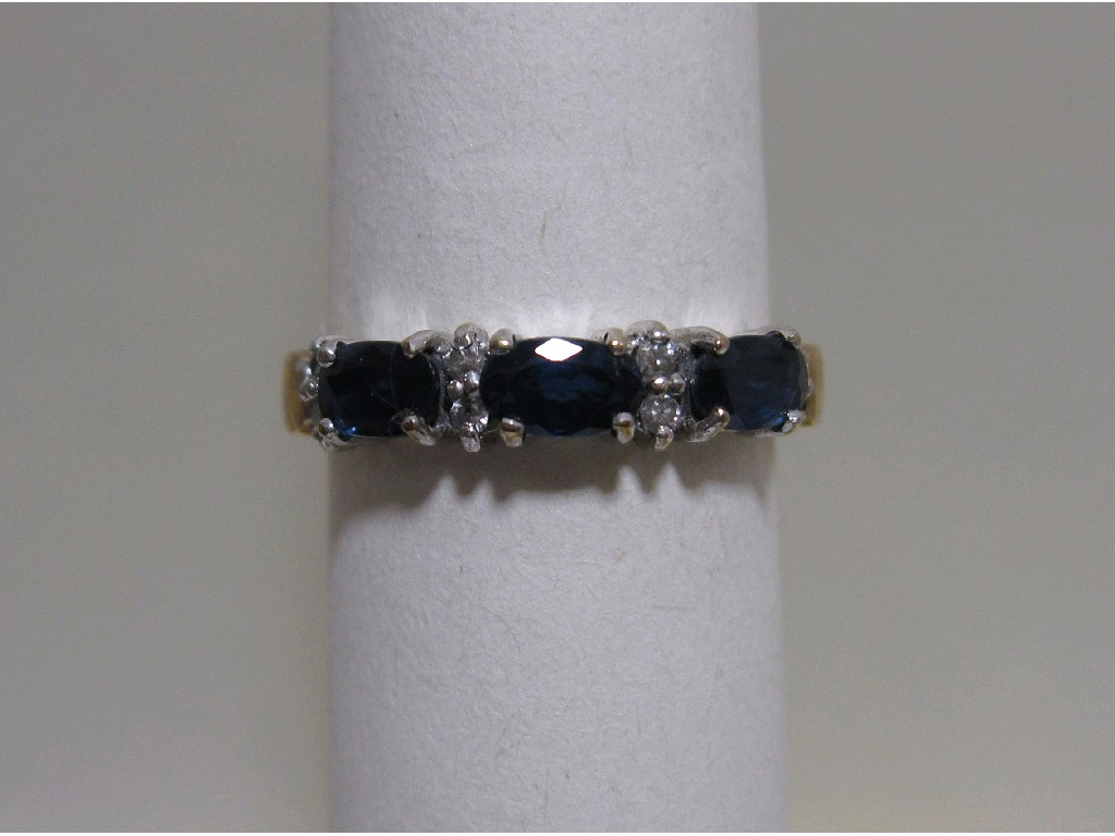 Appraisal: Nine carat gold sapphire and diamond half hoop ring