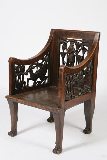 Appraisal: AN EGYPTIAN REVIVAL ARMCHAIR the rectangular back with a pierced