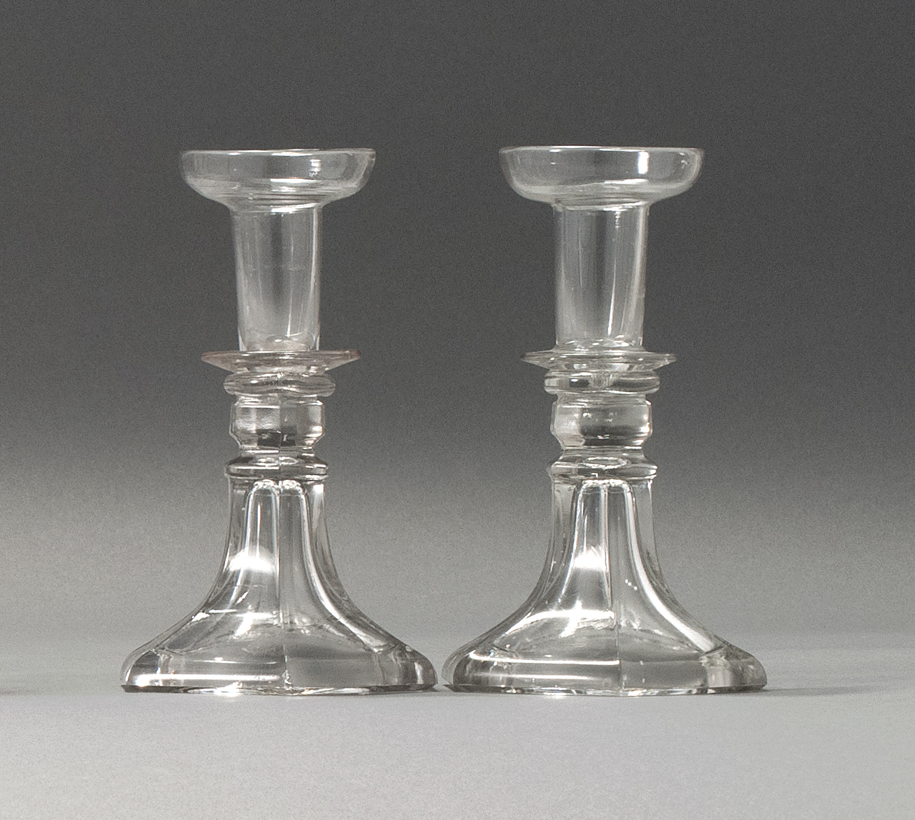 Appraisal: PAIR OF SANDWICH GLASS COMPANY CLEAR GLASS CANDLESTICKS Second Quarter