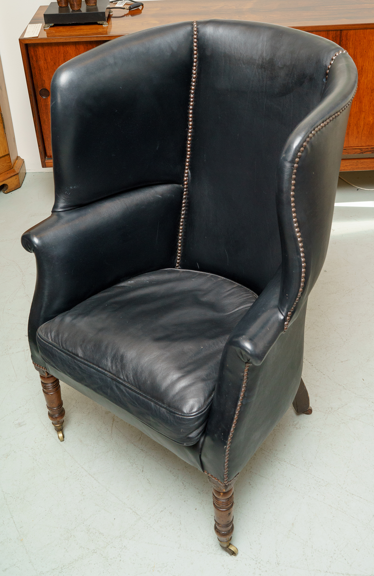 Appraisal: AN IMPRESSIVE GEORGIAN WINGBACK ARMCHAIR Black leather with button details