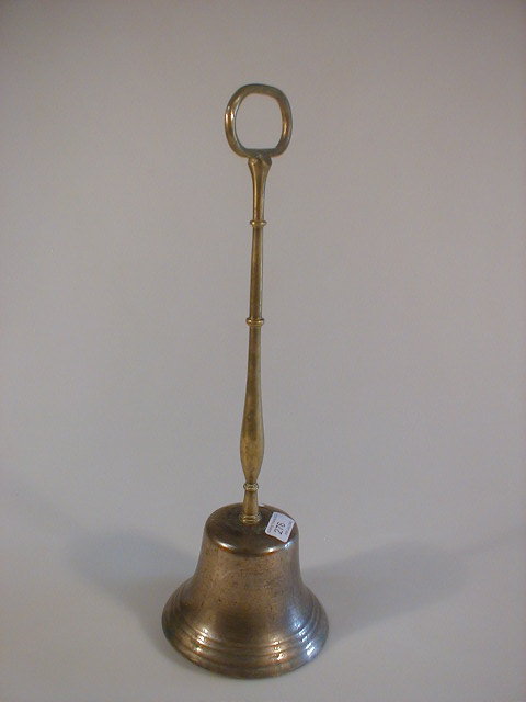 Appraisal: A brass and bell metal door porter in the form