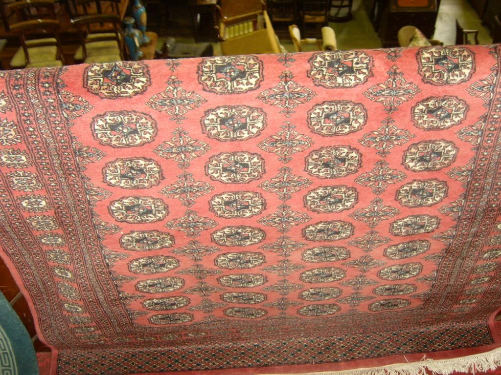 Appraisal: An Afghan carpet with pink ground field and medallion detail