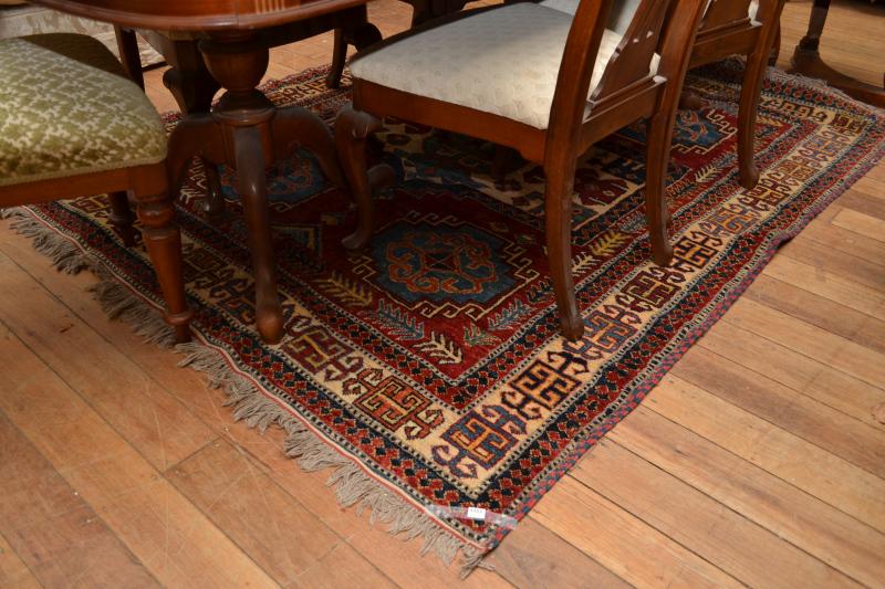 Appraisal: AN AFGHAN TRIBAL RUG IN RED BLUE AND CREAM TONES