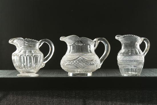 Appraisal: THREE CLEAR CUT PITCHERS American th century Flint glass Pittsburgh