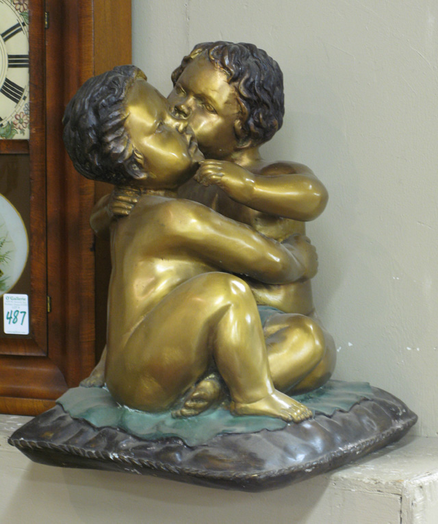 Appraisal: FIGURAL PARCEL-GILT BRONZE SCULPTURE two embracing cherub figures seated on