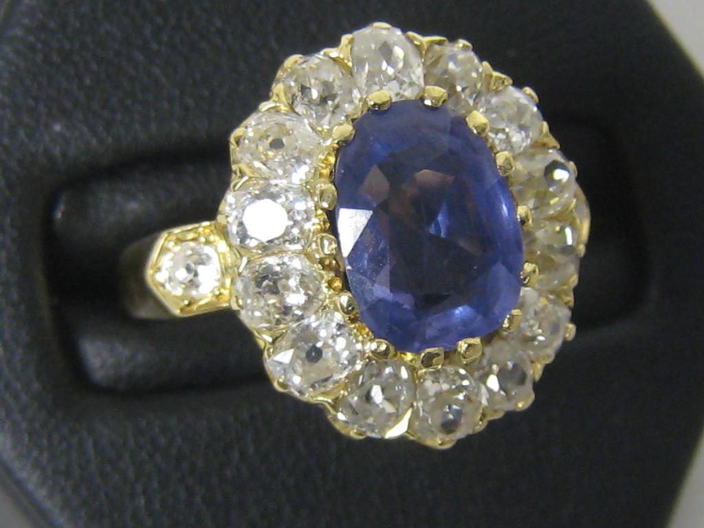 Appraisal: A Sapphire and Diamond Cluster Ring the central oval-cut sapphire