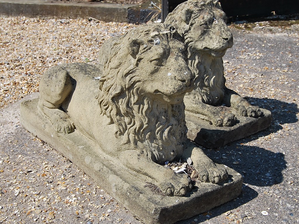 Appraisal: Pair of weathered cast stone recumbant lions