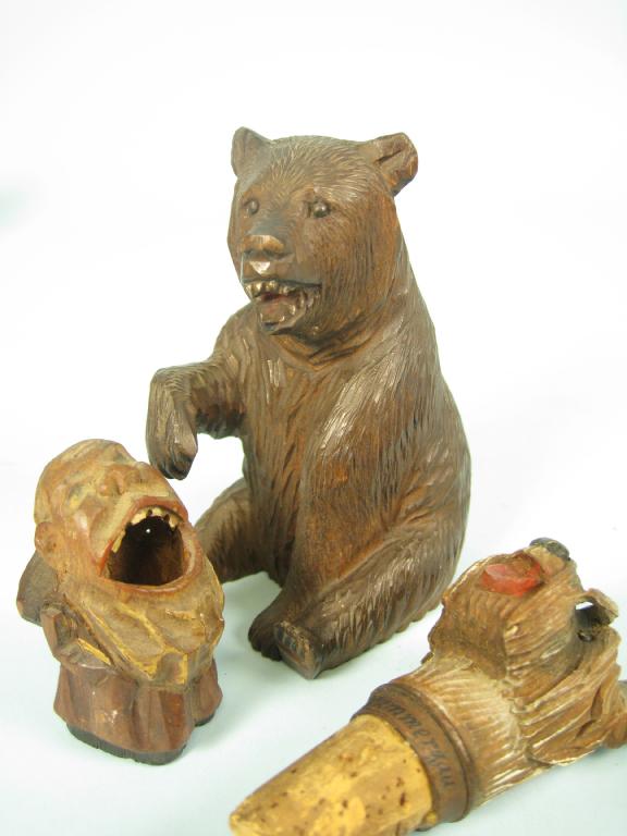 Appraisal: A carved wood Black Forest seated Bear in a Tyrolean