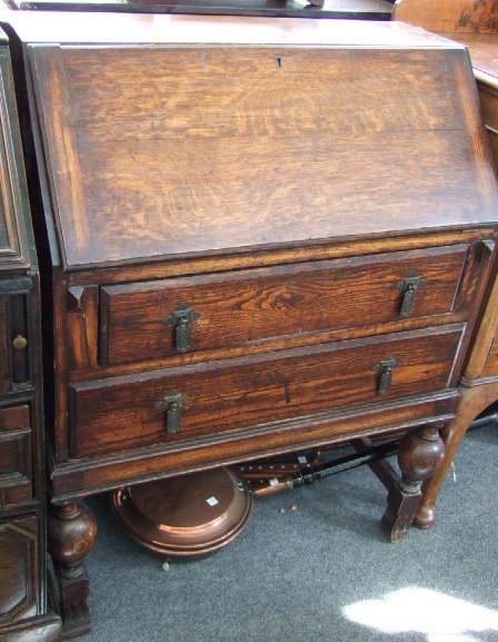 Appraisal: A mid th century oak bureau the fall enclosing a