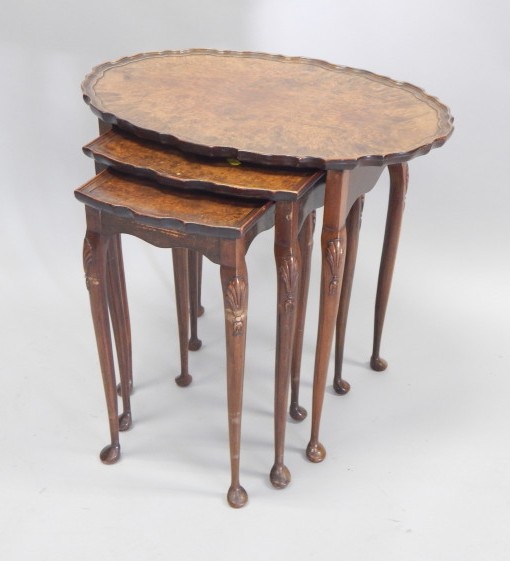 Appraisal: A nest of three walnut tables each with a dished