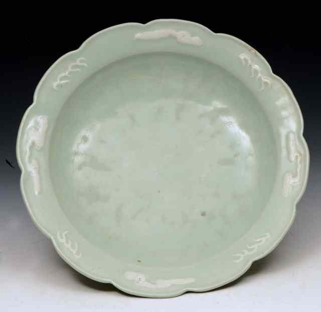 Appraisal: A CHINESE CELADON DISH the border with raised stylised clouds