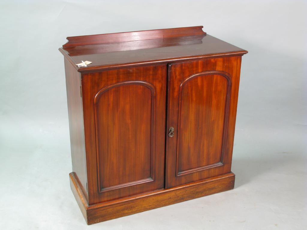 Appraisal: A Victorian mahogany side cupboard enclosed by a pair of