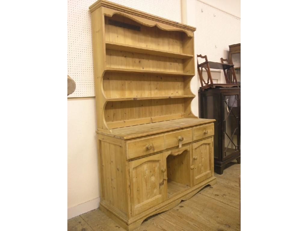 Appraisal: A pine dog-kennel dresser three-shelf plate rack above panelled cupboard