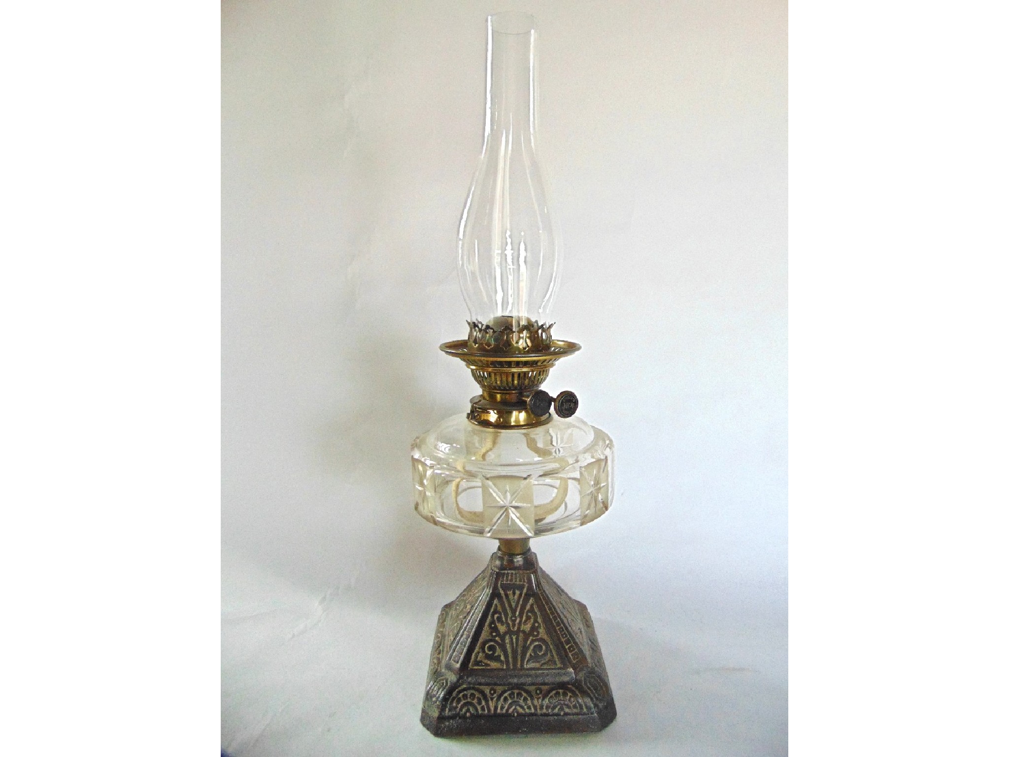 Appraisal: A Victorian oil burning lamp raised on a cast iron