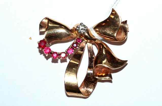 Appraisal: A RUBY AND DIAMOND SET BOW BROOCH claw set diamond