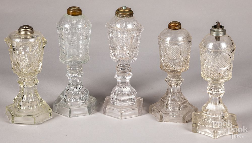 Appraisal: Five colorless glass fluid lamps th c Five colorless glass