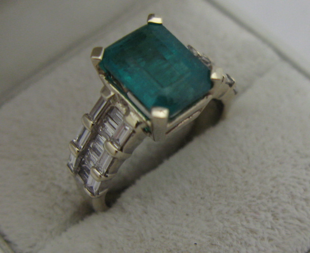 Appraisal: EMERALD DIAMOND AND K GOLD RING centering an emerald-cut green