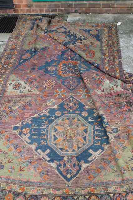 Appraisal: A CAUCASIAN WOOL RUG with stylised lozenge decoration and running