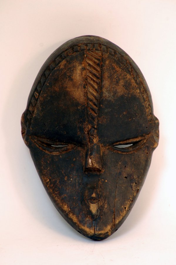 Appraisal: Dan Deangle mask of wood with dark patina having typical