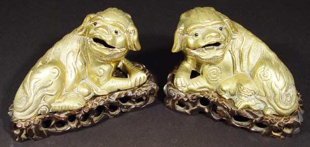 Appraisal: Pair of Oriental bronze dog of foo on carved hardwood