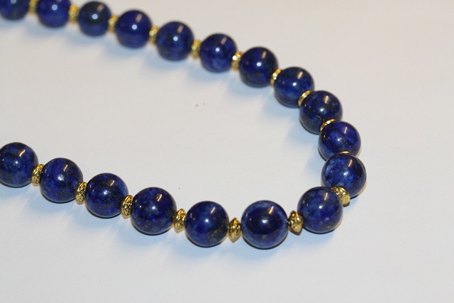 Appraisal: A LAPIS LAZULI BEAD NECKLACE with gilt spacers and clasp