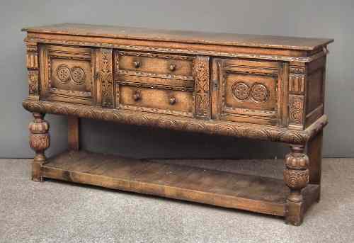 Appraisal: A panelled oak sideboard of '' th Century'' design carved