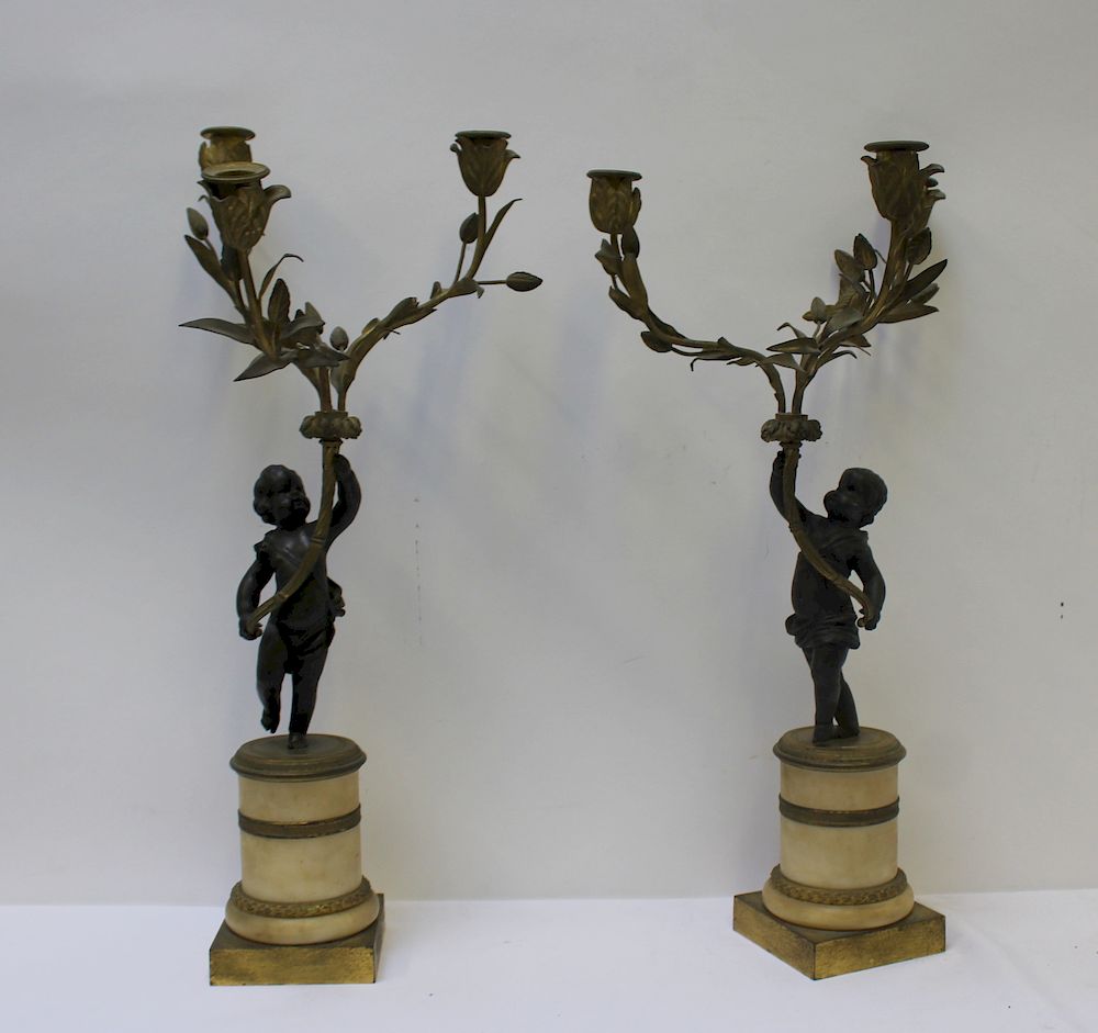 Appraisal: Pair of Patinated and Gilt Bronze Putti Form Candlebra Nice