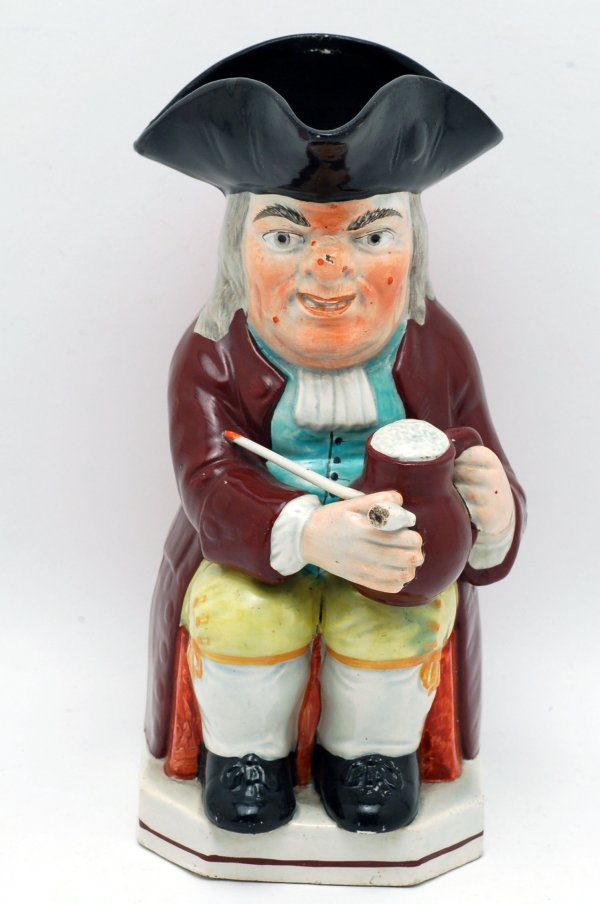 Appraisal: Colonial character pitcher of seated gentleman with ale and pipe